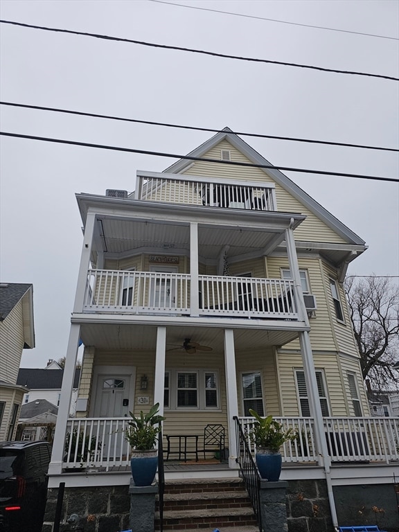 view of front of house with ceiling fan, a porch, and a balcony