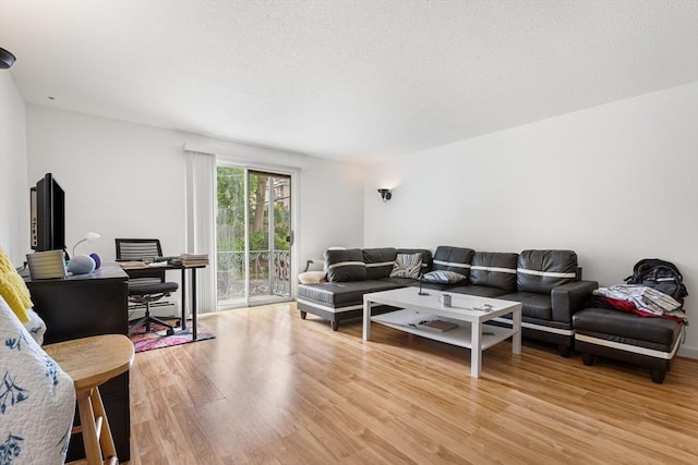 24 Inman St Unit 23, Lawrence, MA 01843 - living area featuring an office area, light wood finished floors, a textured ceiling, and a baseboard radiator