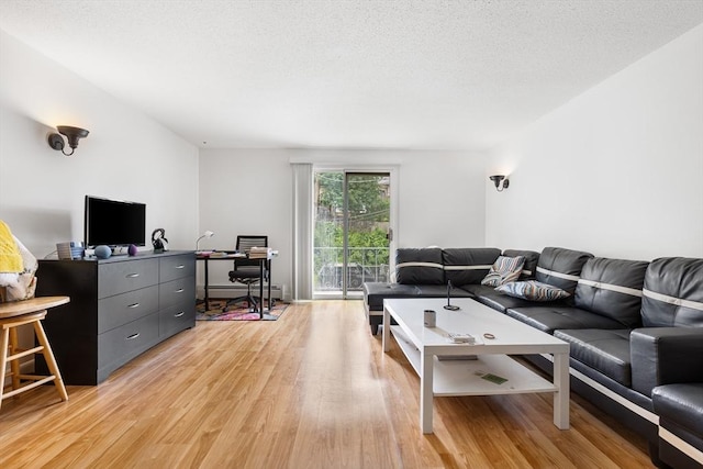 24 Inman St Unit 23, Lawrence, MA 01843 - living room with light wood-type flooring, baseboard heating, a desk, and a textured ceiling