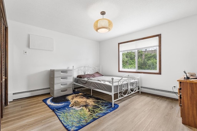 24 Inman St Unit 23, Lawrence, MA 01843 - bedroom featuring a baseboard heating unit and light wood-style flooring