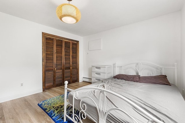 24 Inman St Unit 23, Lawrence, MA 01843 - bedroom featuring a baseboard heating unit, a closet, and wood finished floors