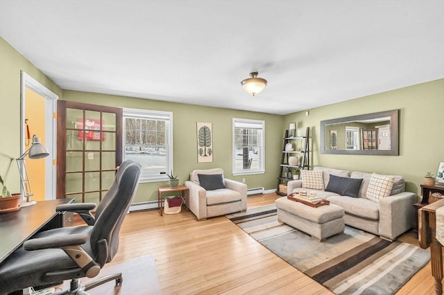 office area featuring a healthy amount of sunlight, baseboard heating, and light hardwood / wood-style flooring