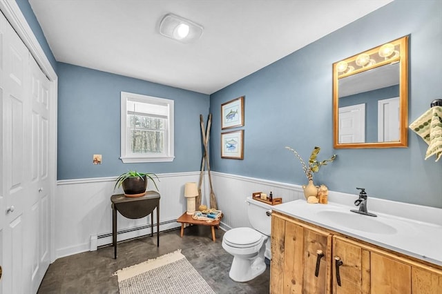 bathroom featuring vanity, a baseboard heating unit, concrete floors, and toilet