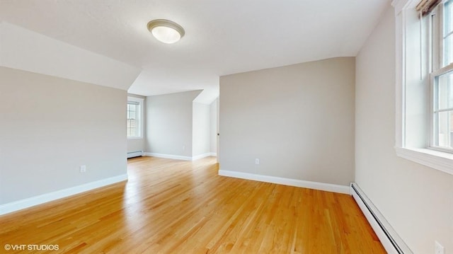 additional living space featuring hardwood / wood-style flooring and a baseboard heating unit