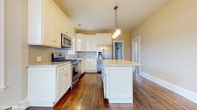 kitchen with white cabinetry, pendant lighting, a kitchen island, and appliances with stainless steel finishes