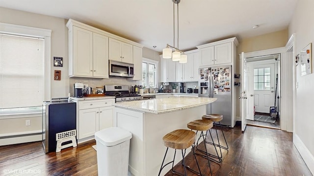 kitchen featuring a center island, hanging light fixtures, appliances with stainless steel finishes, decorative backsplash, and white cabinets