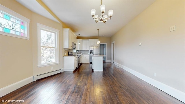 kitchen featuring hanging light fixtures, stainless steel appliances, white cabinets, a kitchen island, and a baseboard radiator