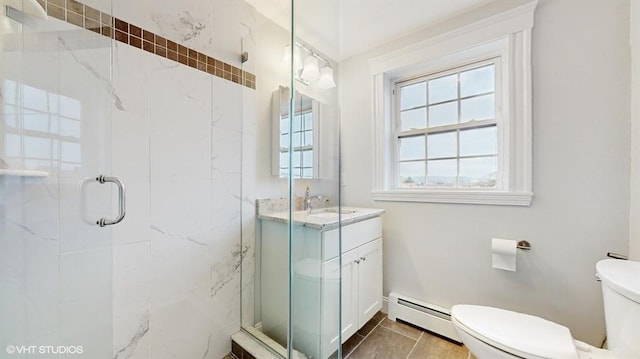 bathroom featuring a shower with door, a baseboard heating unit, vanity, tile patterned floors, and toilet