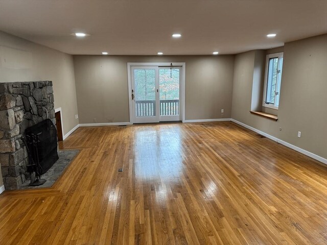 unfurnished living room with recessed lighting, baseboards, a fireplace, and hardwood / wood-style floors