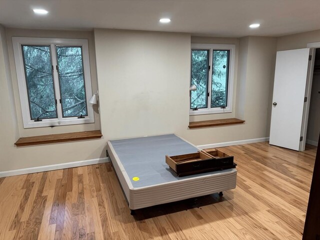 bedroom with baseboards, wood finished floors, and recessed lighting