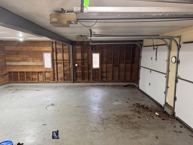 garage with wooden walls and a garage door opener