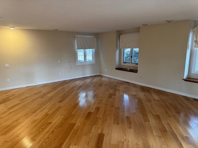 empty room with light wood-style flooring and baseboards