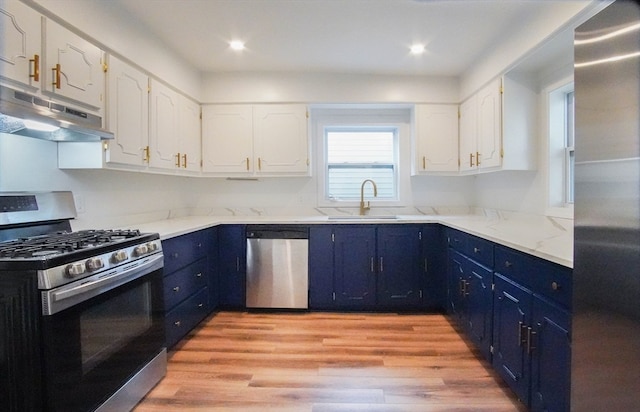 kitchen featuring blue cabinets, sink, white cabinetry, appliances with stainless steel finishes, and light wood-type flooring