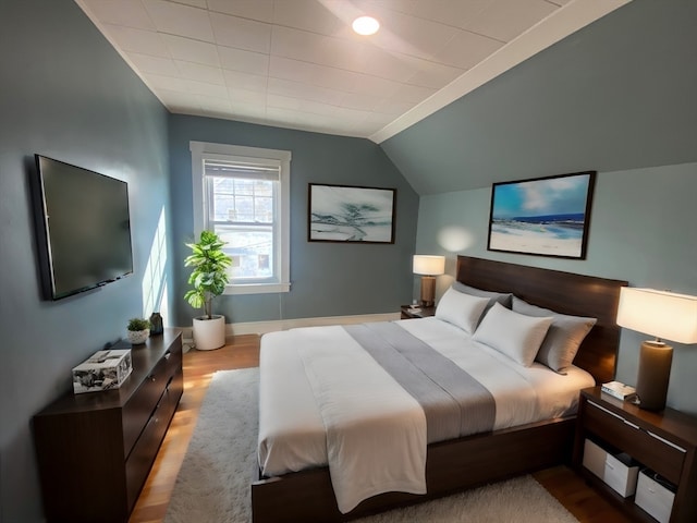 bedroom featuring vaulted ceiling and light hardwood / wood-style flooring