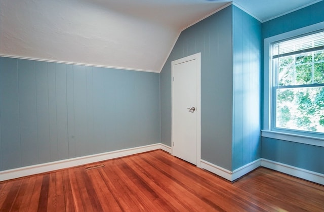 additional living space with hardwood / wood-style flooring and vaulted ceiling