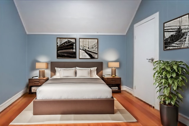 bedroom featuring ornamental molding, vaulted ceiling, and hardwood / wood-style floors