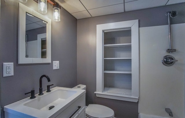 bathroom featuring a shower, a paneled ceiling, vanity, and toilet