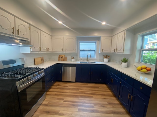 kitchen featuring sink, white cabinetry, blue cabinetry, appliances with stainless steel finishes, and light hardwood / wood-style floors