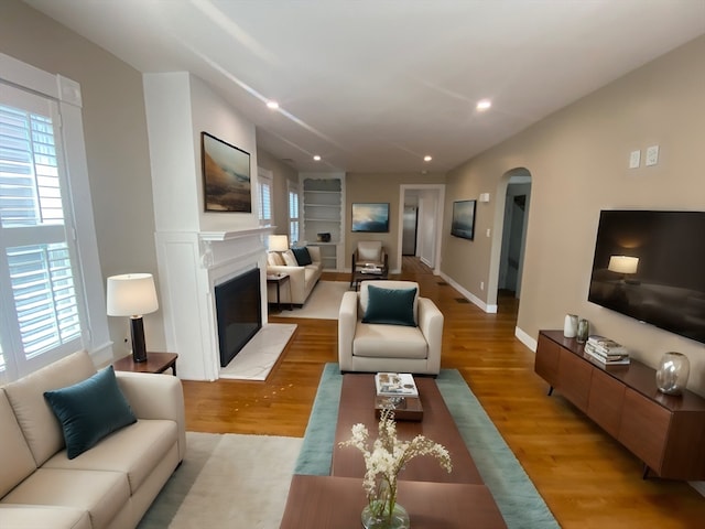 living room featuring light hardwood / wood-style flooring and built in features