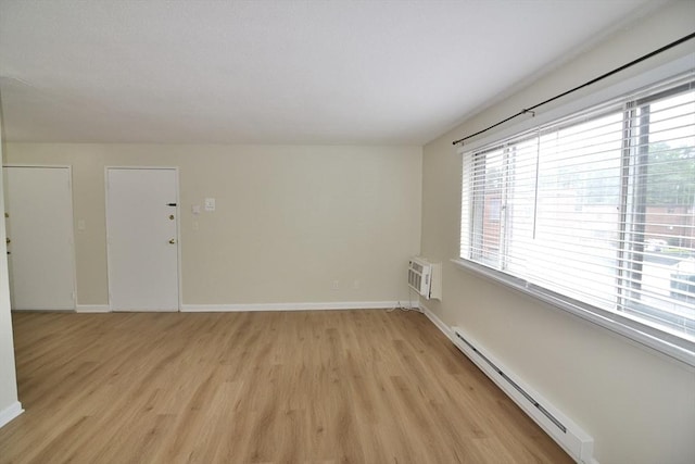 77 Nicholas Rd Unit I, Framingham, MA 01701 - spare room with baseboard heating, light wood-style flooring, healthy amount of natural light, and a wall mounted AC