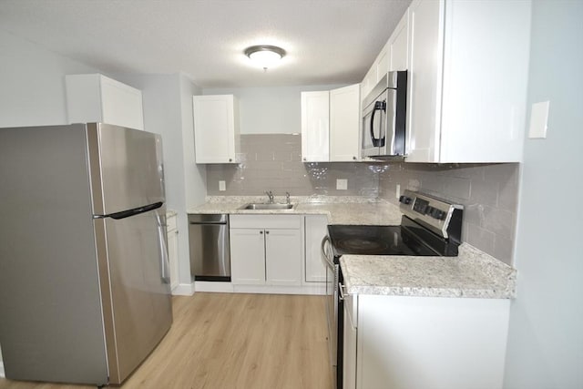 77 Nicholas Rd Unit I, Framingham, MA 01701 - kitchen featuring appliances with stainless steel finishes, a sink, light wood-style floors, white cabinetry, and light countertops