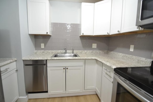 77 Nicholas Rd Unit I, Framingham, MA 01701 - kitchen featuring appliances with stainless steel finishes, a sink, tasteful backsplash, and white cabinetry