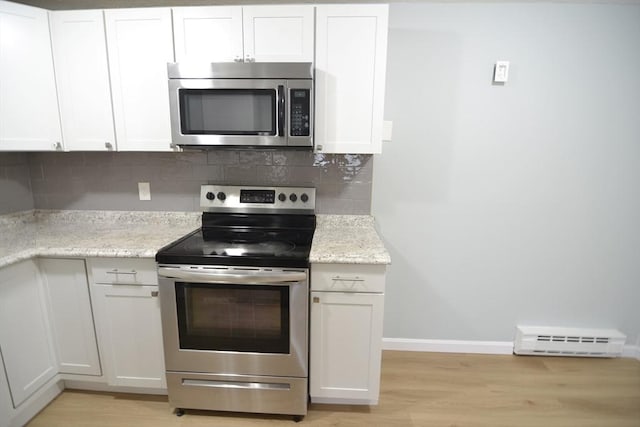 77 Nicholas Rd Unit I, Framingham, MA 01701 - kitchen with appliances with stainless steel finishes, a baseboard heating unit, light wood-type flooring, and decorative backsplash