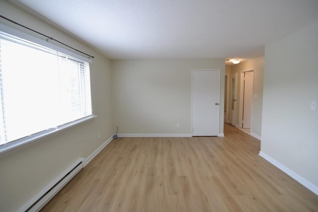 77 Nicholas Rd Unit I, Framingham, MA 01701 - empty room with a baseboard radiator, light wood-type flooring, and baseboards