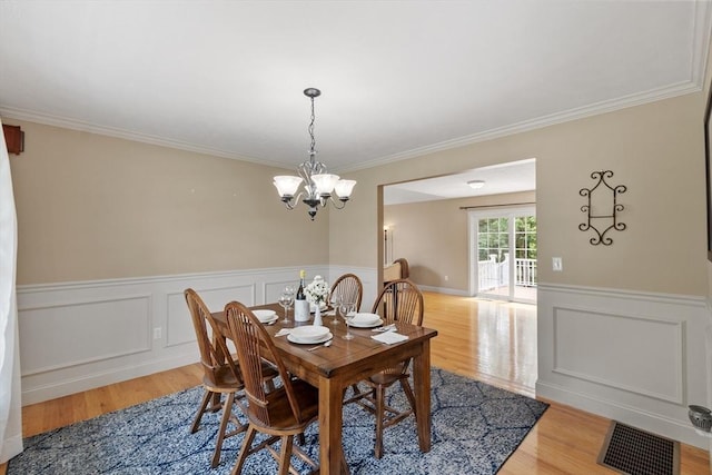 65 Saint Anthony St, Fitchburg, MA 01420 - dining room featuring light wood finished floors, a chandelier, ornamental molding, wainscoting, and a decorative wall