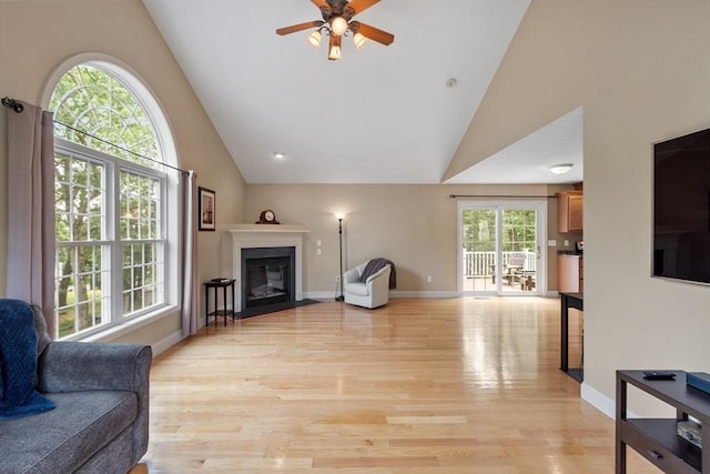 65 Saint Anthony St, Fitchburg, MA 01420 - living area with high vaulted ceiling, ceiling fan, light wood finished floors, a fireplace with flush hearth, and baseboards