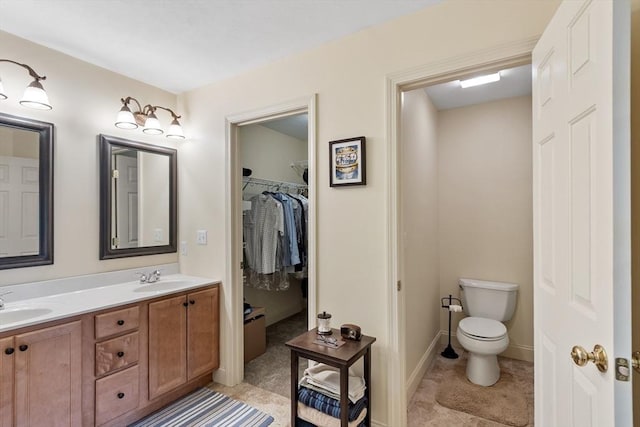 65 Saint Anthony St, Fitchburg, MA 01420 - full bathroom featuring double vanity, toilet, a spacious closet, baseboards, and tile patterned floors