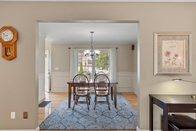 65 Saint Anthony St, Fitchburg, MA 01420 - dining area featuring light wood-style floors, a chandelier, a wainscoted wall, crown molding, and a decorative wall