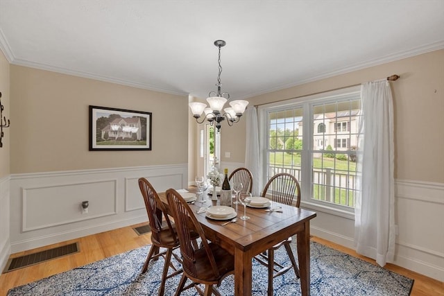 65 Saint Anthony St, Fitchburg, MA 01420 - dining area featuring a chandelier, light wood-style floors, wainscoting, and crown molding