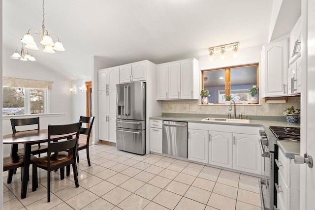 kitchen with high end appliances, white cabinets, and a sink