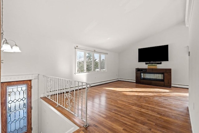 unfurnished living room with a glass covered fireplace, lofted ceiling, stairway, wood finished floors, and baseboard heating