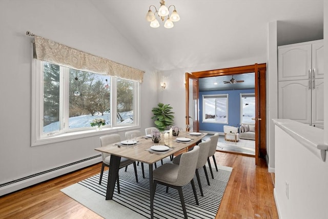 dining space with lofted ceiling, a notable chandelier, light wood-style flooring, and baseboard heating