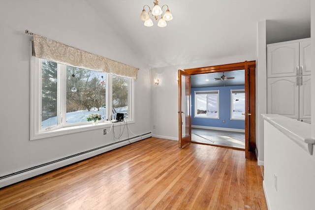 spare room with lofted ceiling, baseboard heating, an inviting chandelier, light wood-type flooring, and baseboards