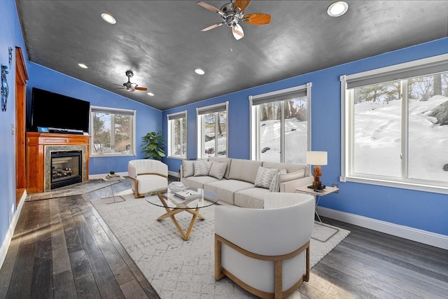 living area with lofted ceiling, hardwood / wood-style flooring, ceiling fan, and a premium fireplace