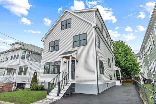 view of front facade featuring entry steps, fence, and central AC unit