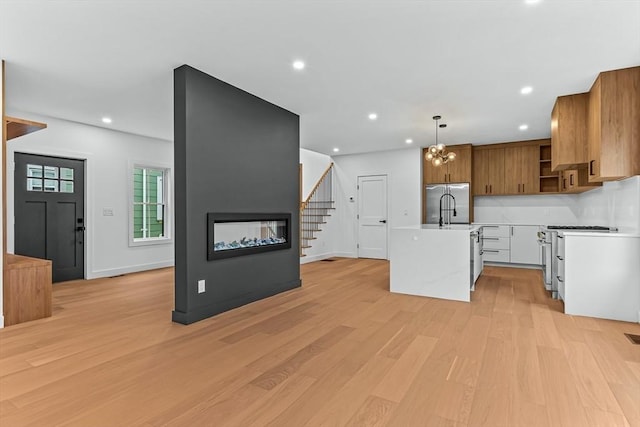 kitchen with open shelves, light countertops, premium appliances, light wood-style flooring, and recessed lighting