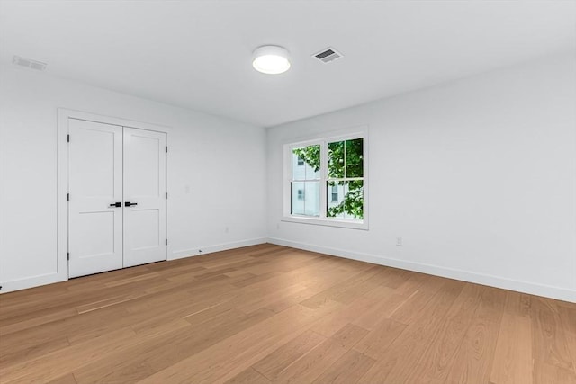spare room featuring light wood-style flooring and baseboards
