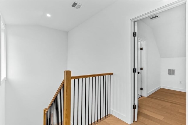 hall with lofted ceiling, light wood-style flooring, an upstairs landing, baseboards, and recessed lighting