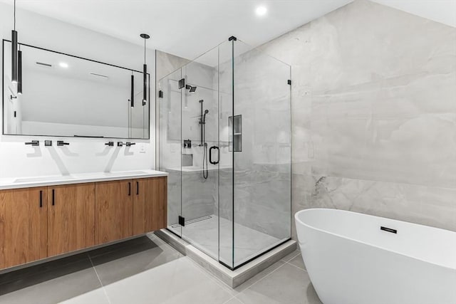 bathroom featuring a soaking tub, a stall shower, double vanity, tile patterned flooring, and recessed lighting