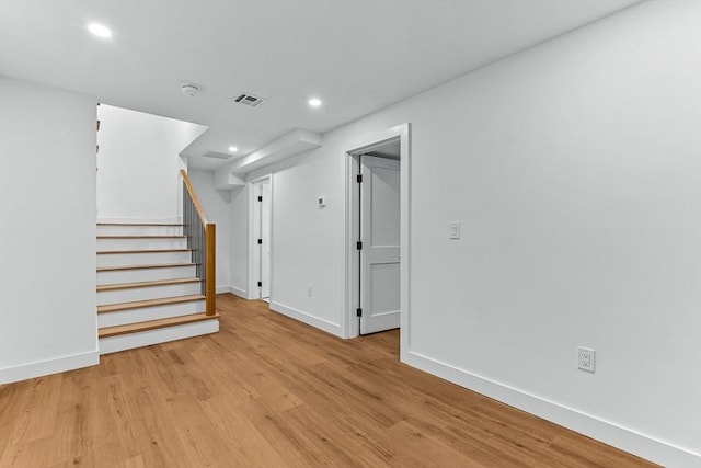 spare room with baseboards, light wood finished floors, stairway, recessed lighting, and a smoke detector