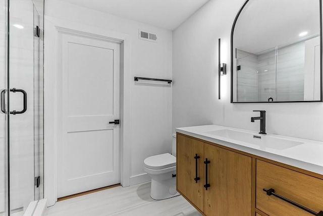full bath featuring toilet, a stall shower, wood finished floors, and vanity