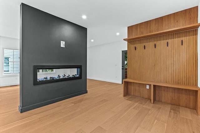mudroom featuring wood finished floors, recessed lighting, a multi sided fireplace, and baseboards