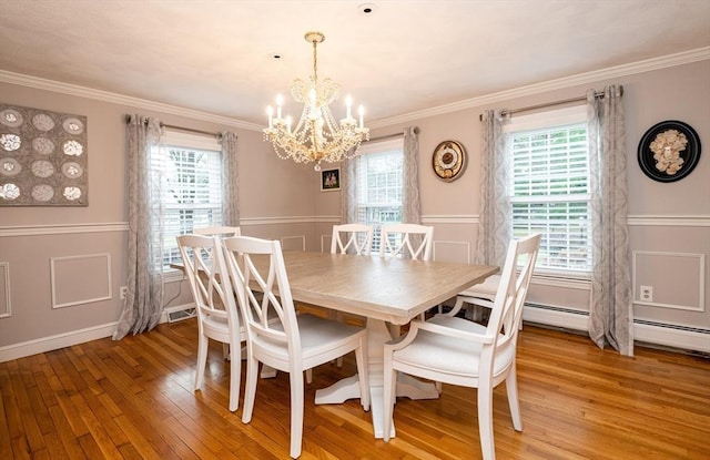 dining area with hardwood / wood-style floors, an inviting chandelier, and a wealth of natural light