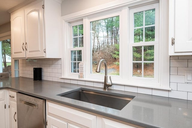 kitchen featuring dishwasher, white cabinetry, sink, and tasteful backsplash