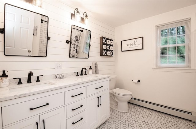 bathroom with vanity, wood walls, toilet, and baseboard heating