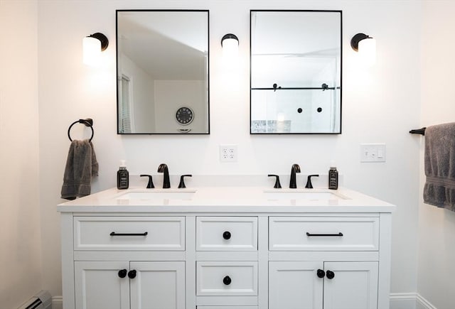 bathroom featuring baseboard heating and vanity